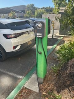 Green EV charging station at a parking space