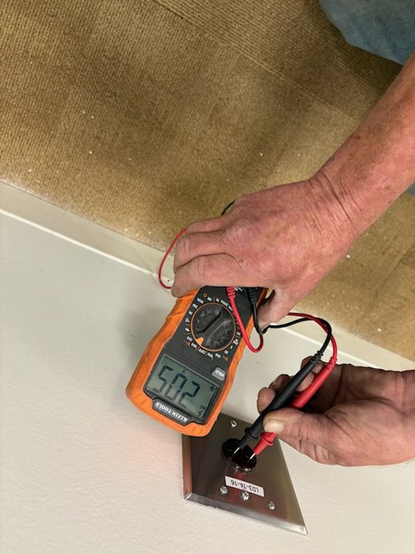 Electrician testing a receptacle with a multimeter