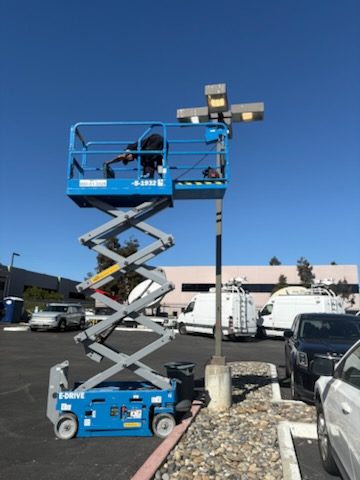 Electrician on a scissor lift working on a light pole